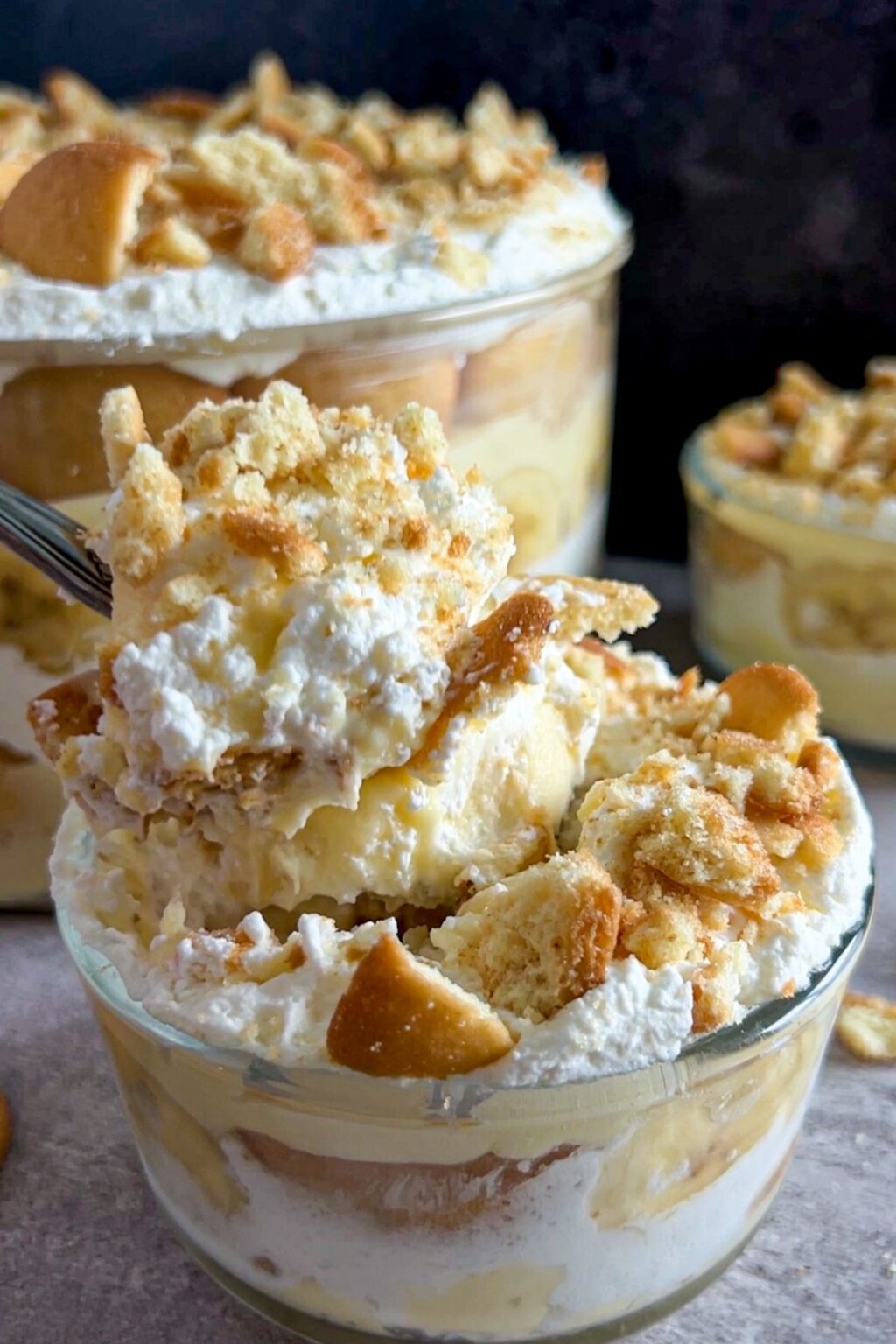 A spoonful of the best southern banana pudding, full of pillowy whipped cream, soft cakey vanilla wafers and banana pudding.