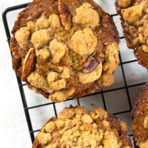 Bakery style banana nut muffins on a wire baking rack.