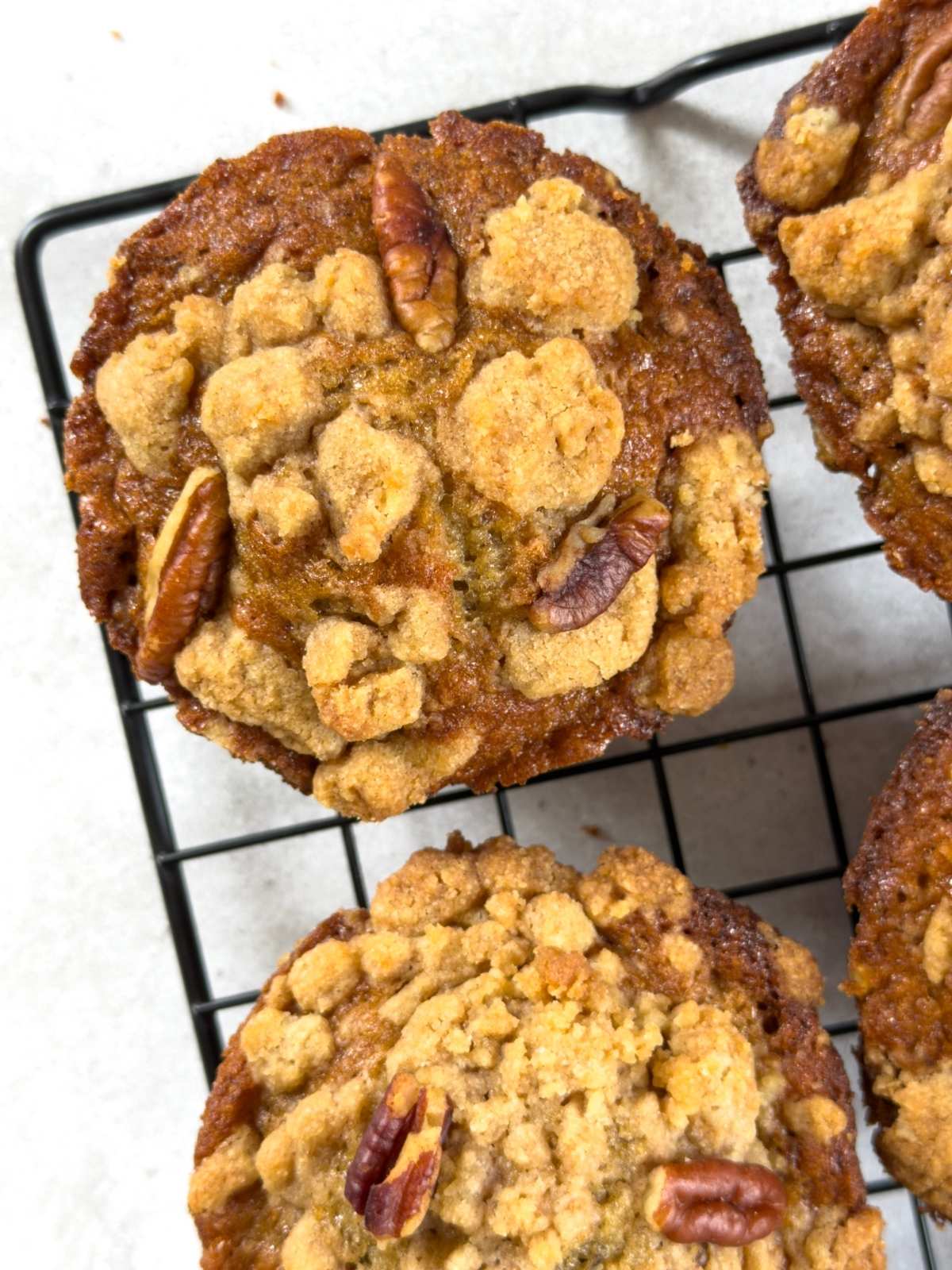 Bakery style banana nut muffins on a wire baking rack.