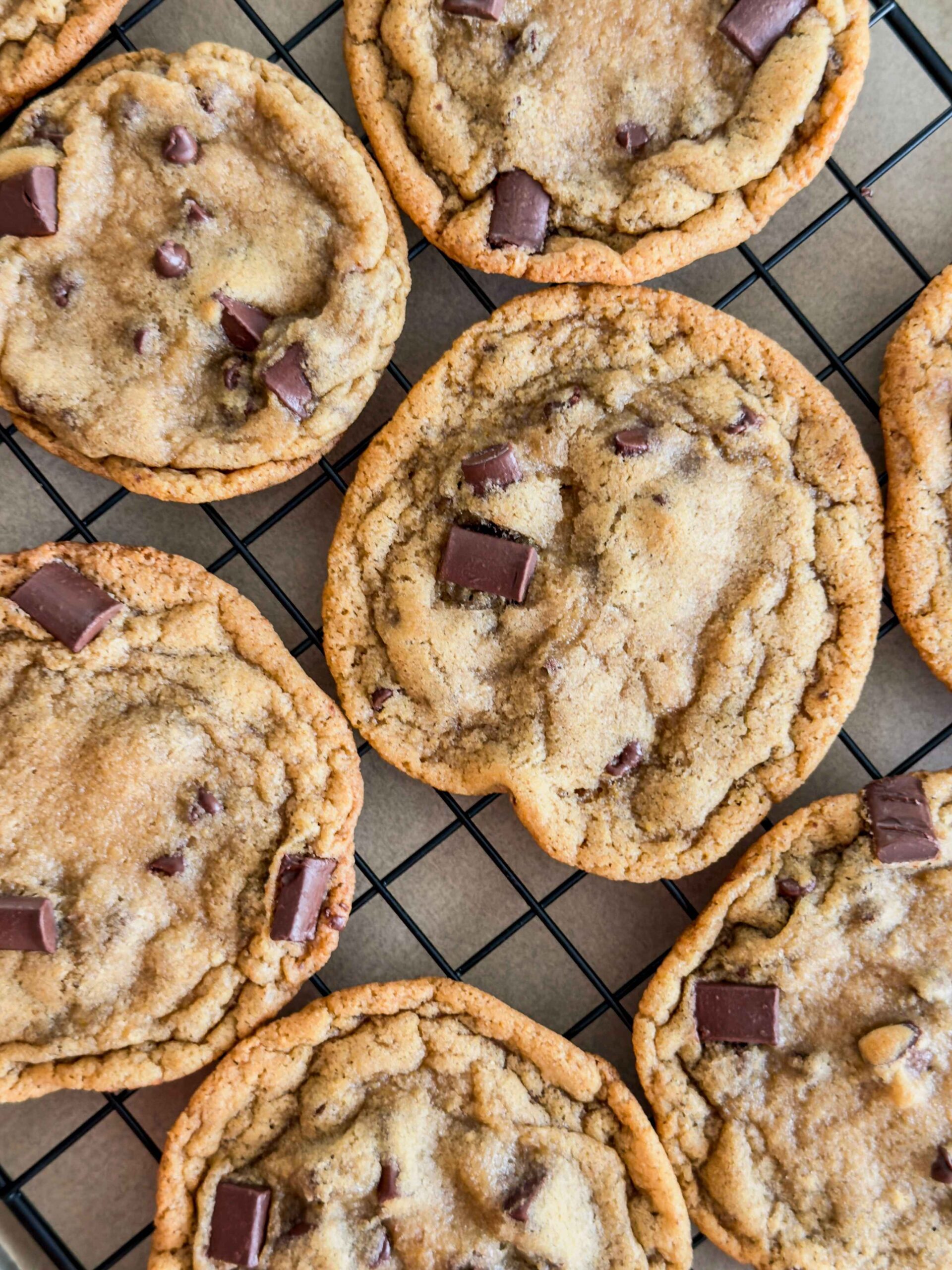 Magnolia style chocolate chip cookies on a baking rack